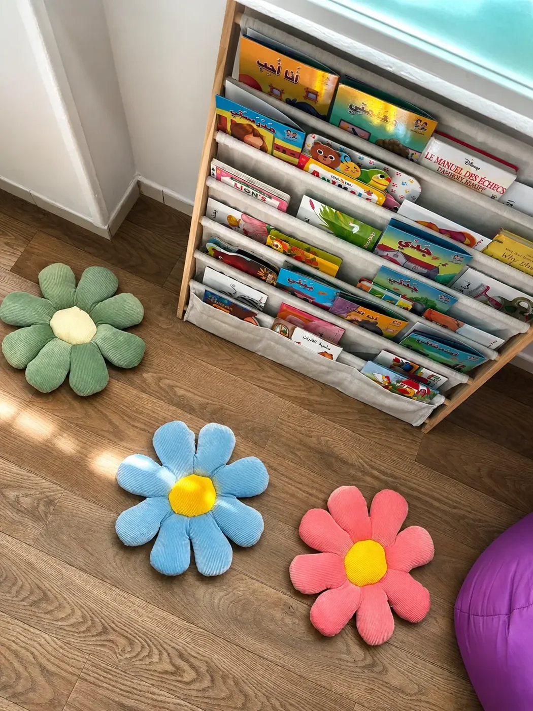 Étagère à livres pour enfants et coussins fleurs sur parquet