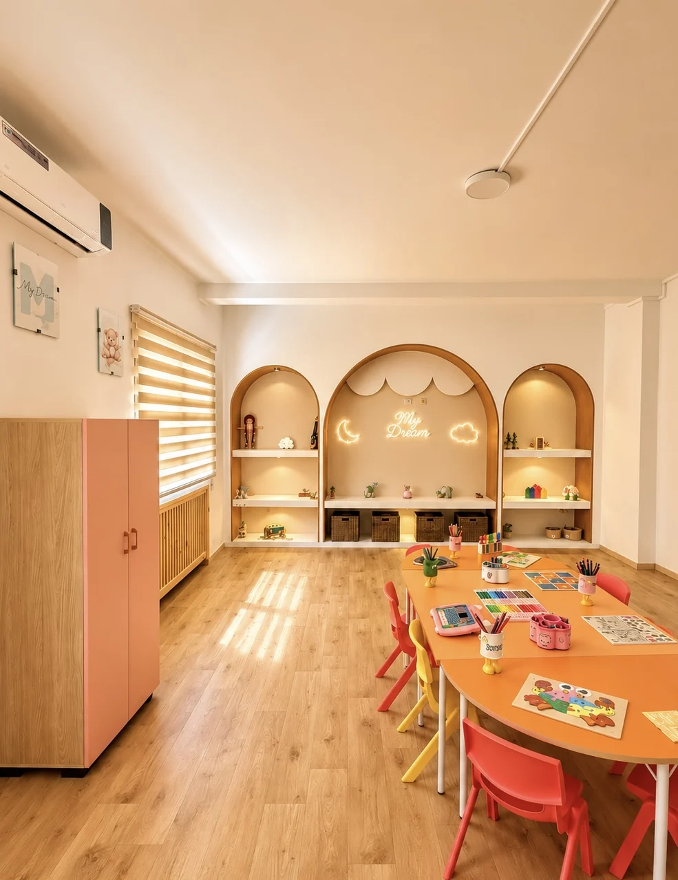 Salle d'activités claire avec niches en arche et mobilier bas